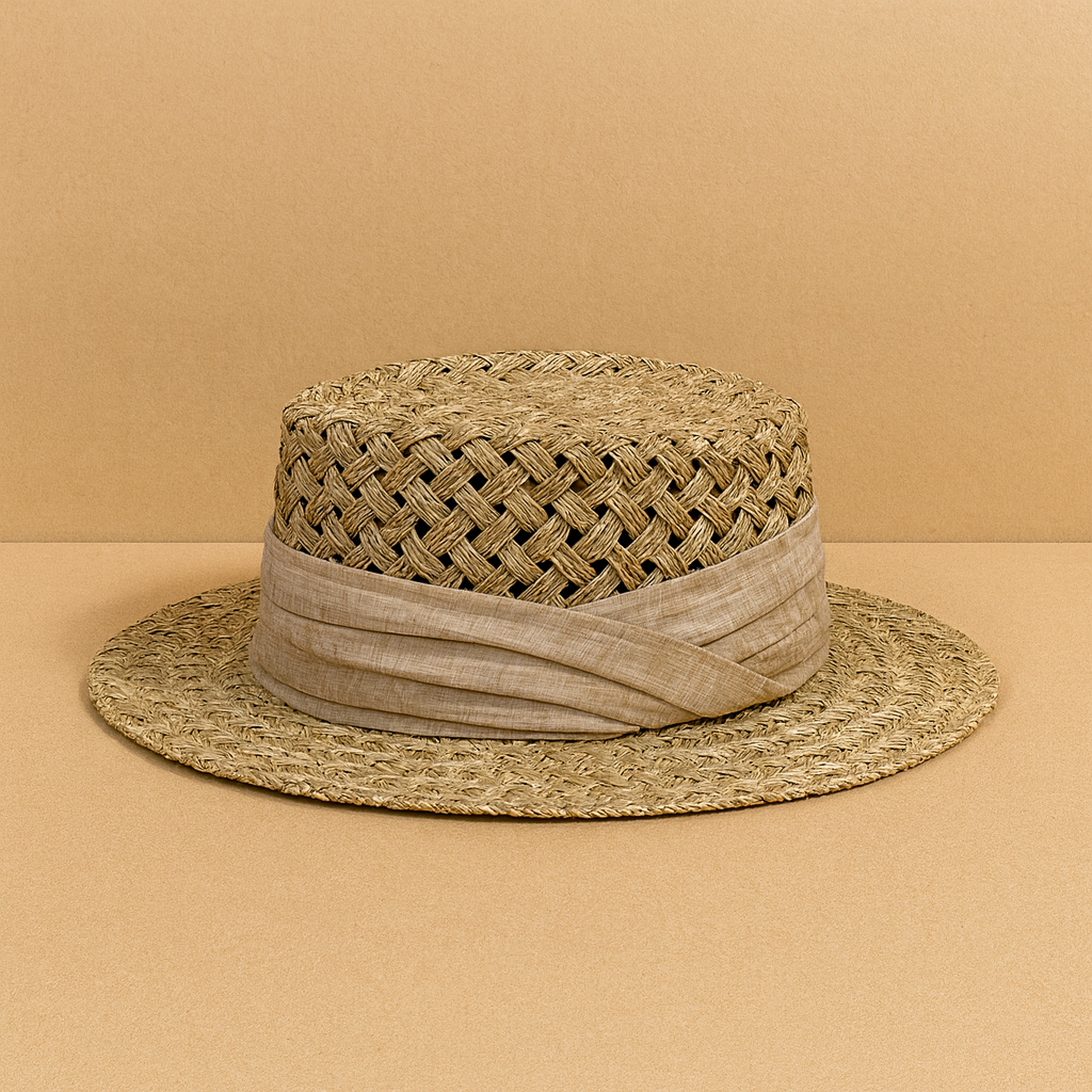 Handwoven vintage-style straw sun hat with a beige fabric band, displayed on a warm neutral background.