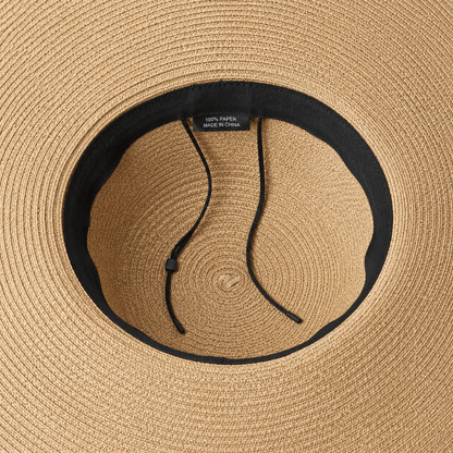 Inside view of an oversized straw sun hat showing the adjustable inner band and drawstring detail