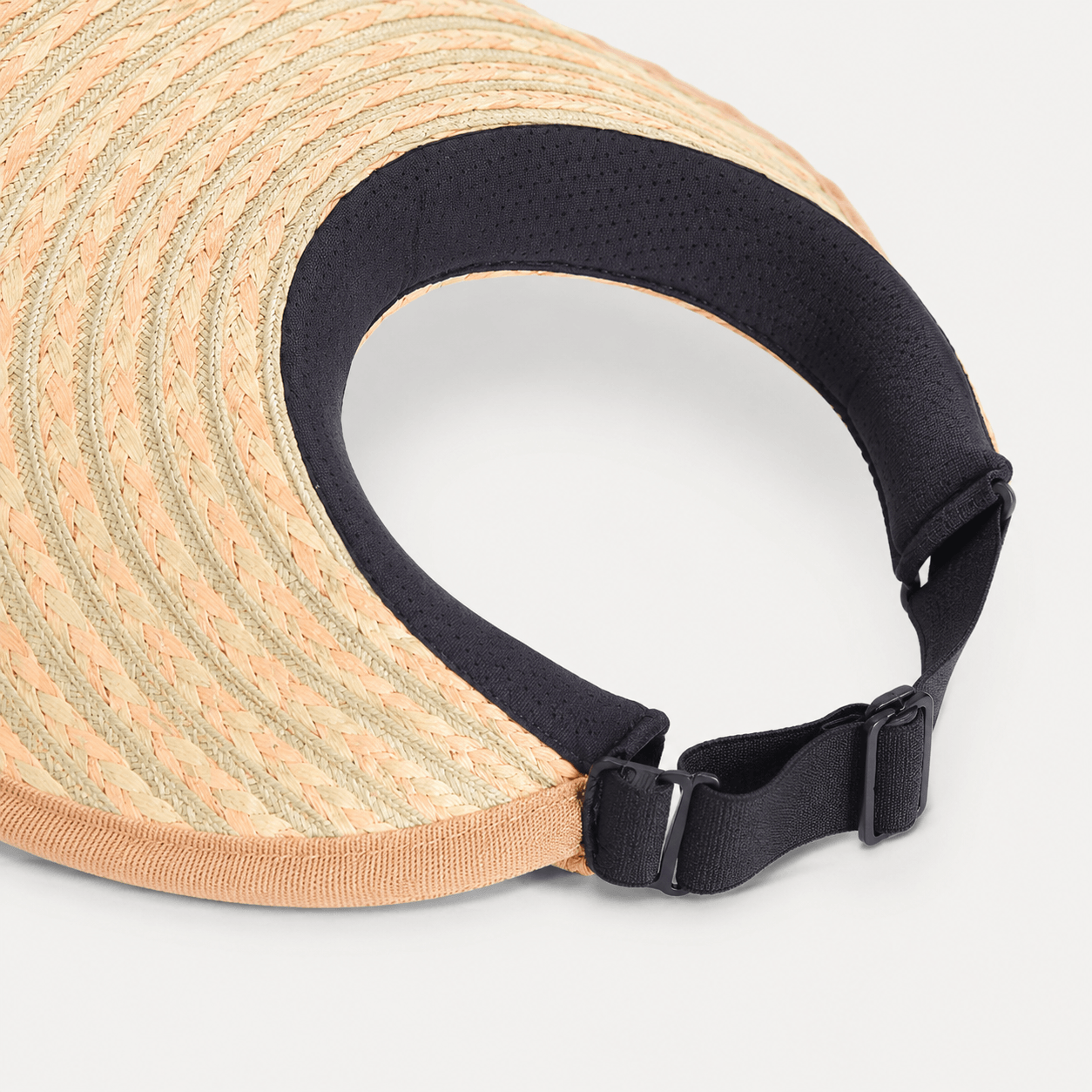 Inside view of a braided paper straw visor showing the black inner band and adjustable buckle strap