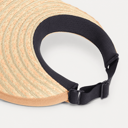 Inside view of a braided paper straw visor showing the black inner band and adjustable buckle strap