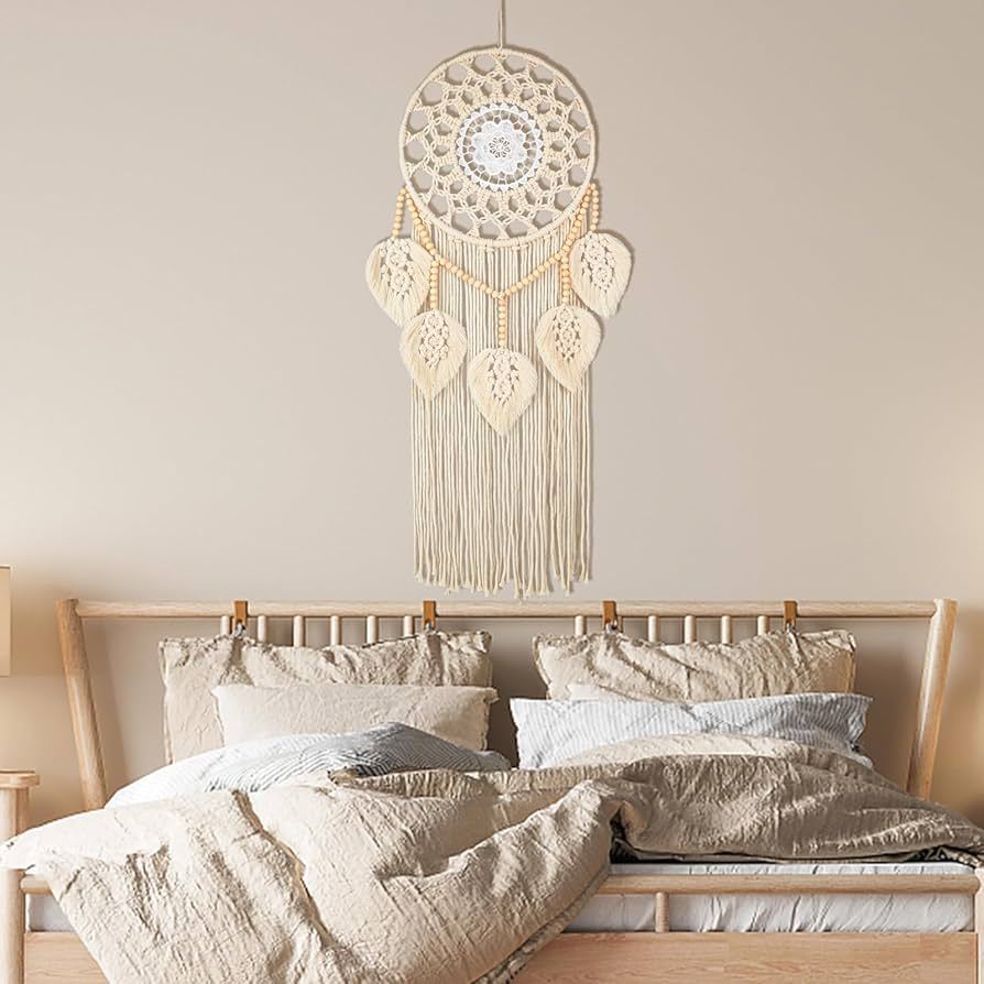 Large macrame wall hanging above a beige bed in a natural bohemian bedroom setting.