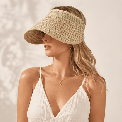 Side portrait of a woman wearing a green khaki wide brim straw sun visor with a white dress