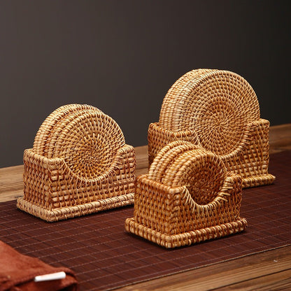 Three rattan coaster sets in small, medium, and large sizes shown on brown table mat under warm lighting.