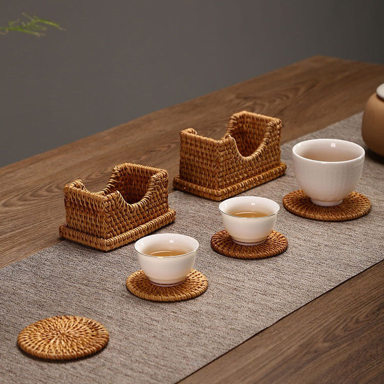 Rattan coaster sets displayed on tea table with cups and teapot in minimalist Asian-style setting.