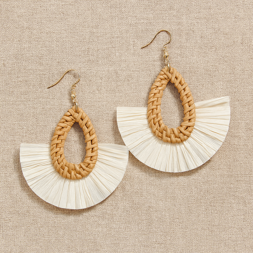 Pair of handmade rattan fan earrings with gold hooks on neutral linen fabric background.