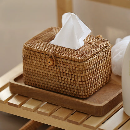 Handmade rattan tissue box with tissue inserted, placed on light wooden shelf in a cozy natural setting.