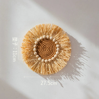 Medium round raffia straw wall decor with central rope circle and wooden beads, 27.5 cm in diameter.