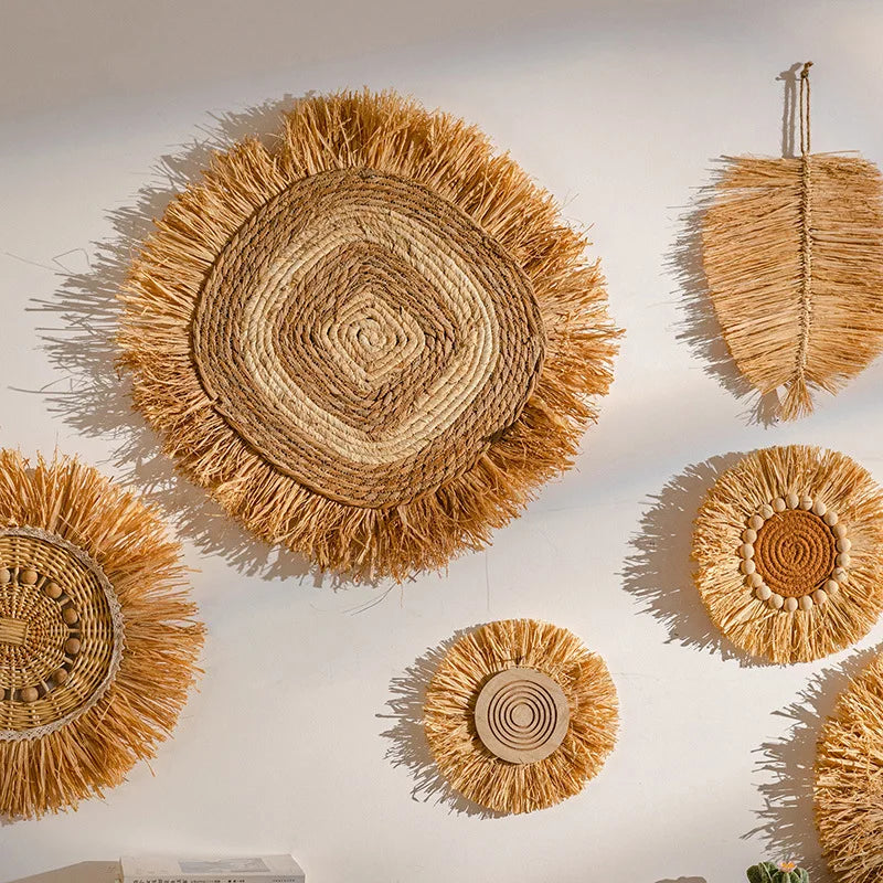 Close-up of hand-woven raffia straw wall plates featuring natural fibers and circular textures on a white wall.