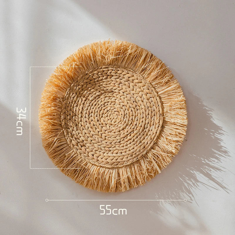 Large round raffia straw wall decoration featuring tight spiral weave and natural fringe, 55 cm wide.