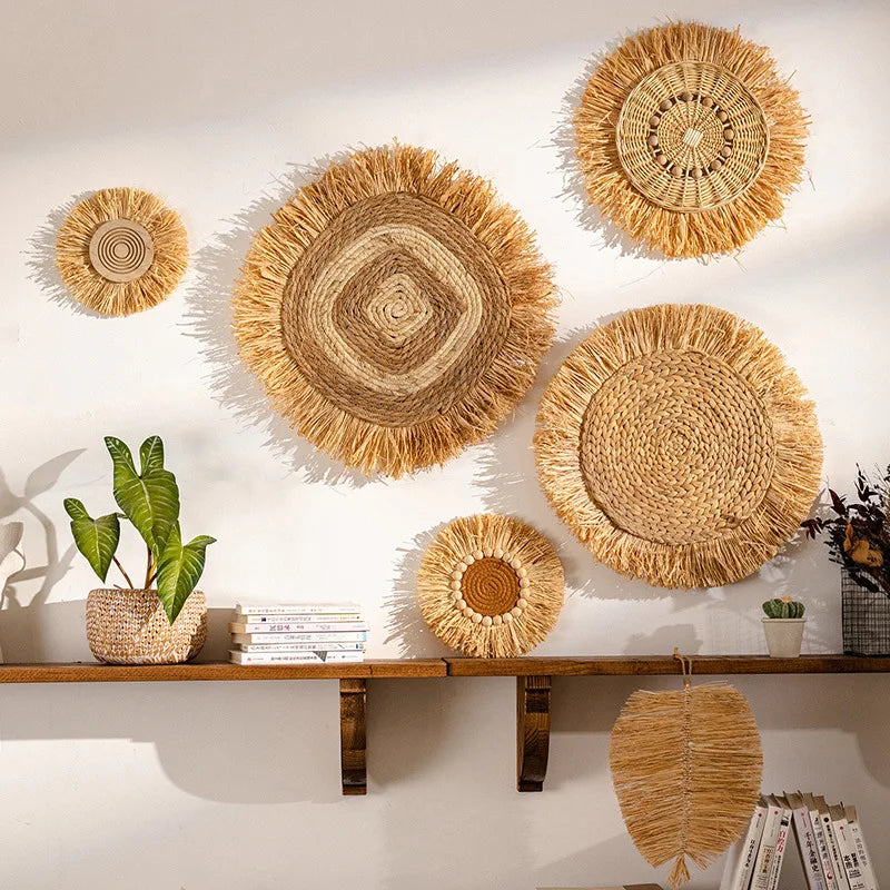 Set of hand-woven raffia straw wall plates in different sizes and patterns displayed above a wooden shelf.