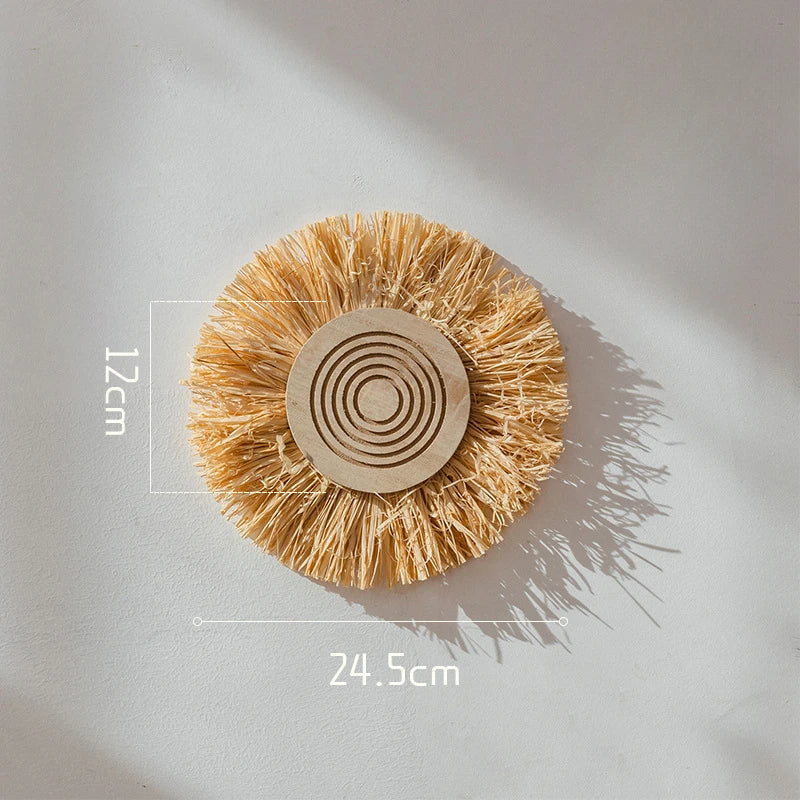 Small round raffia straw wall decor piece with concentric circles, measuring 24.5 cm wide and 12 cm deep.