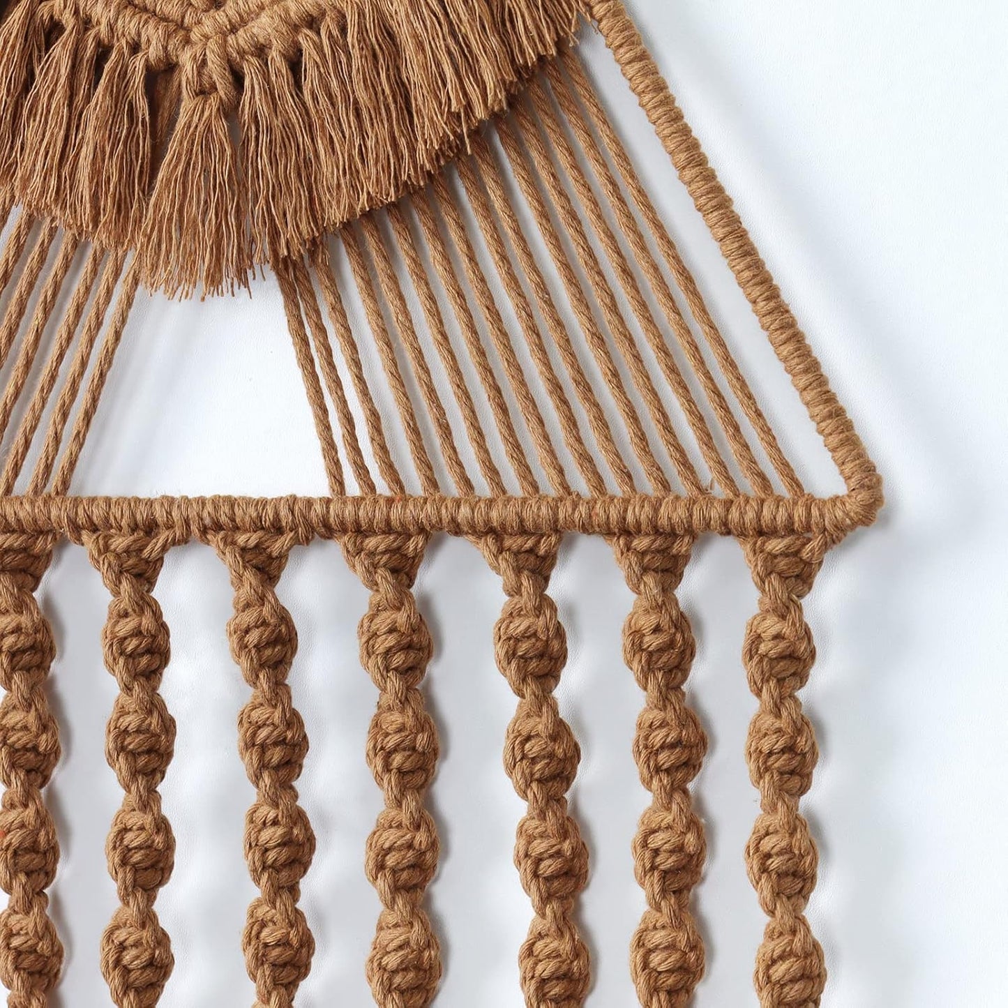 Close-up of handwoven macrame detailing showing twisted rope texture and tassel craftsmanship.