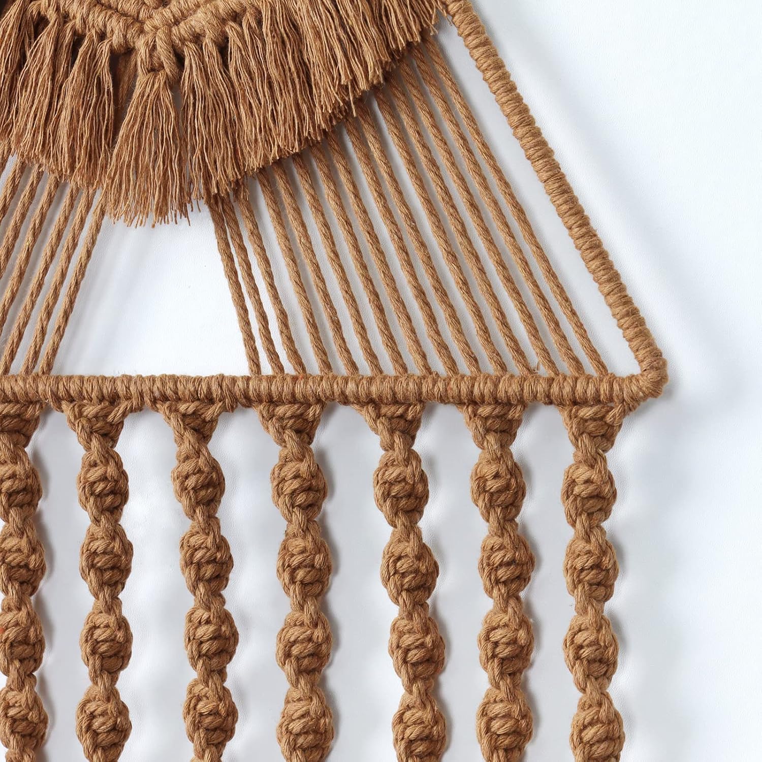 Close-up of handwoven macrame detailing showing twisted rope texture and tassel craftsmanship.