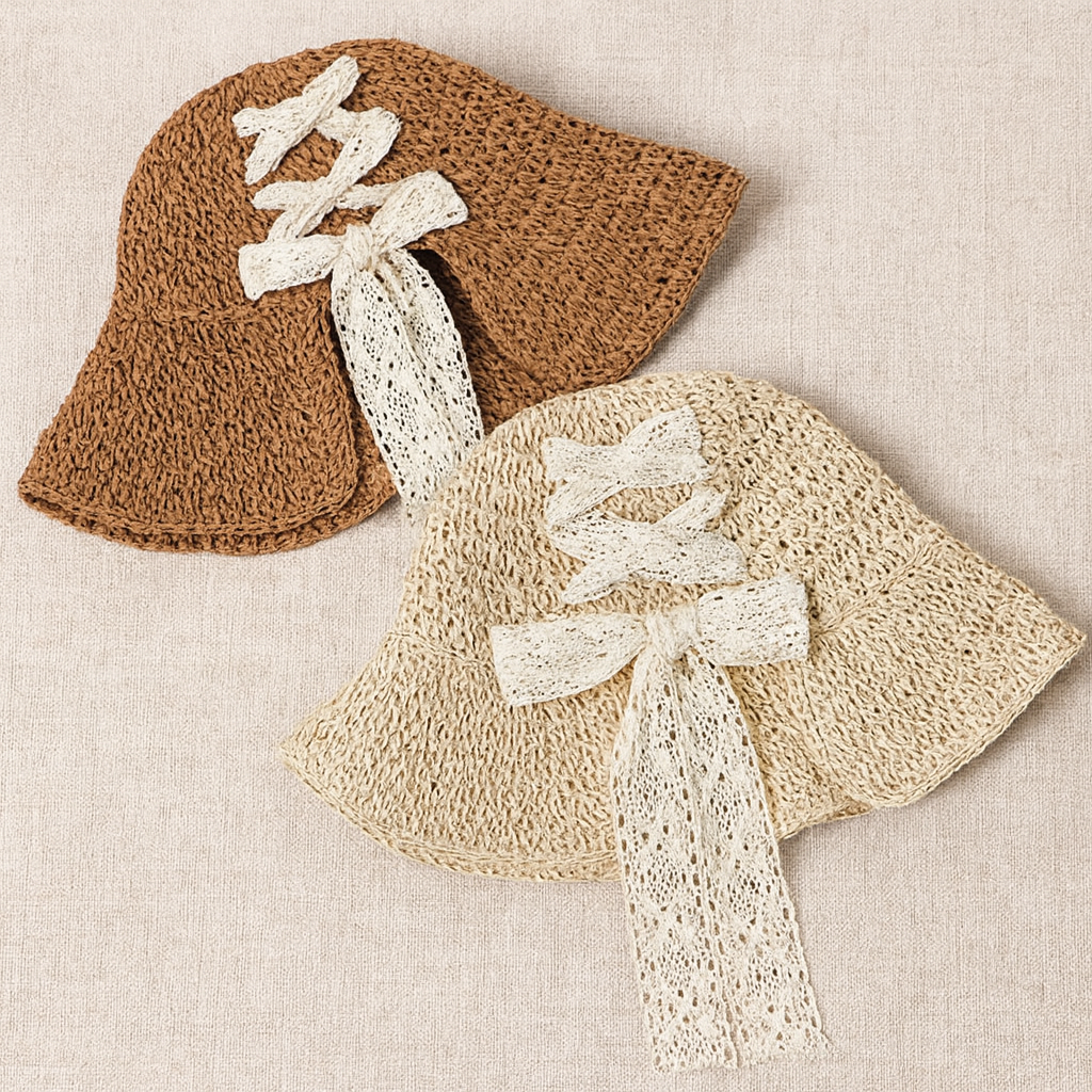 Two lace ribbon straw hats in brown and beige tones, displayed flat on linen fabric surface.