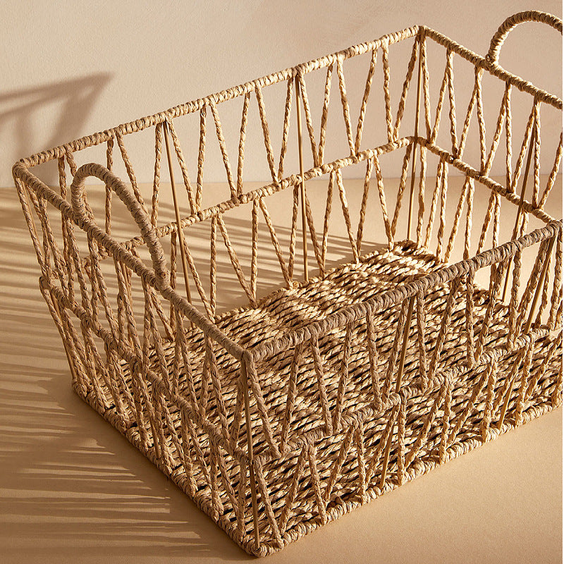 Empty rectangular rattan laundry basket showing open lattice weave and shadow lines from sunlight.