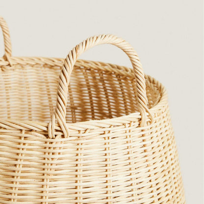 Dual handles connection detail on handwoven rattan laundry basket with wrapped attachment.