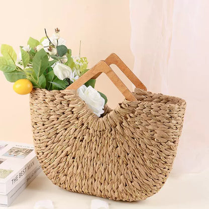 Straw tote bag filled with white flowers and greenery, creating a light and natural lifestyle scene.