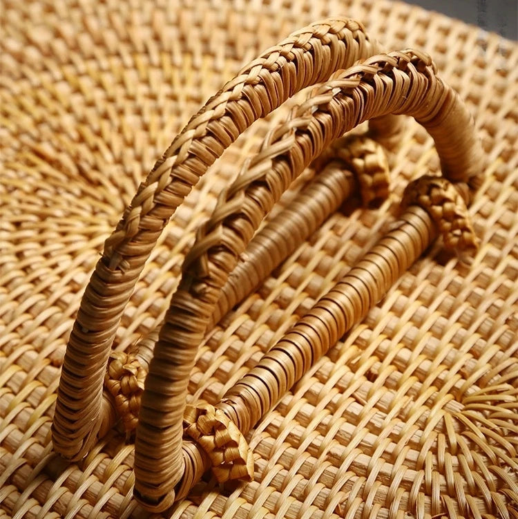 Close-up view of woven rattan handle showing its double-arch design and fine natural texture.