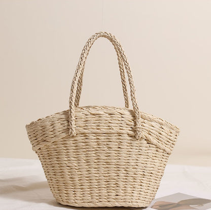 Plain light straw tote bag without decorations, showing clean weaving texture and structured handles.