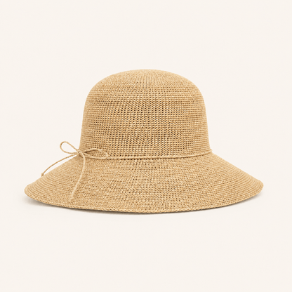 Natural woven wide brim straw sun hat in beige with a delicate side bow tie