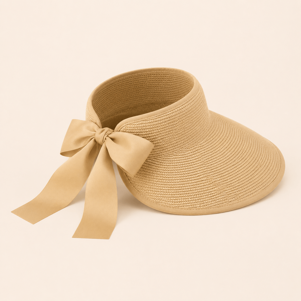 Angled product view of a beige paper straw visor hat with a large ribbon bow
