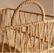 Cropped macro of rattan handle arch on the basket, textured wrapping visible.