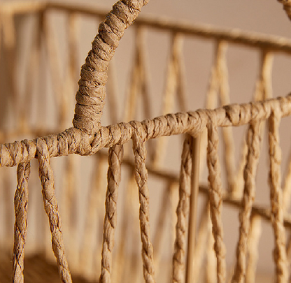 Detail of rattan frame corner showing twisted rope joints and vertical lattice strands.