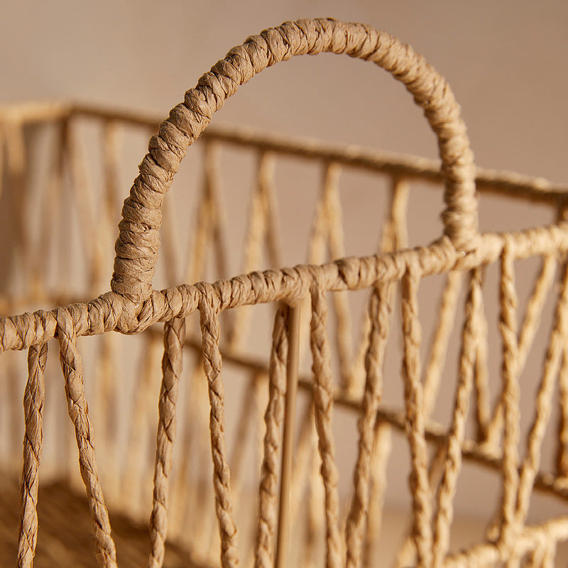 Close-up of rounded rattan handle wrapped with twine on the storage basket.