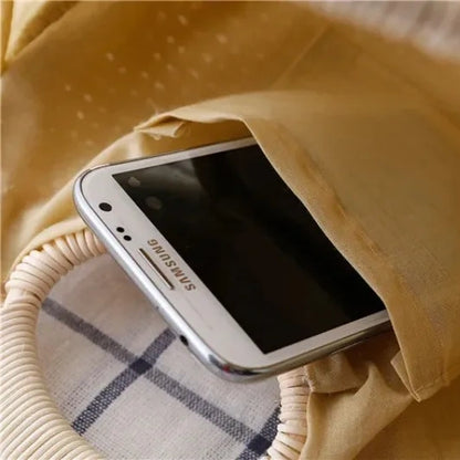 Inside view of straw tote bag showing spacious compartment holding a phone, by Solmerea.