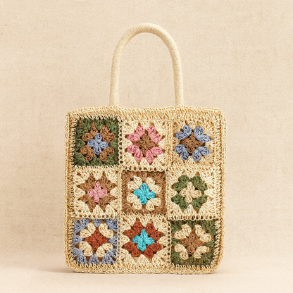 “Front close-up of light straw crochet shoulder bag featuring multicolor floral embroidery, by Solmerea.”
