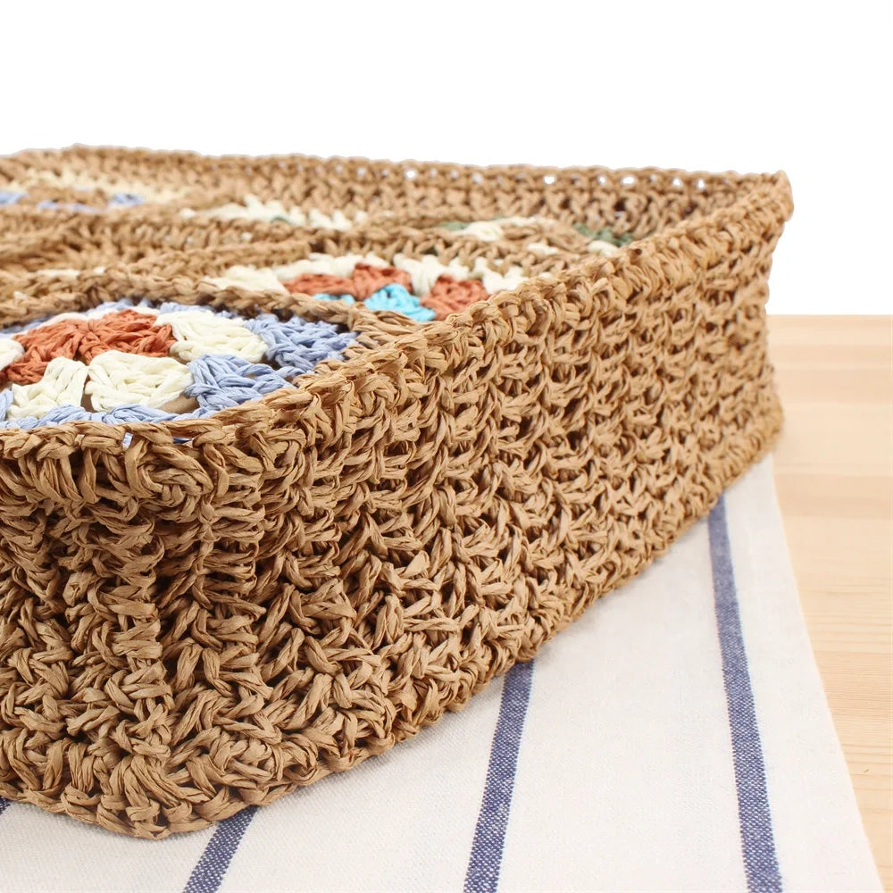 “Bottom close-up of embroidered straw shoulder bag showing dense handwoven texture and sturdy construction, by Solmerea.”