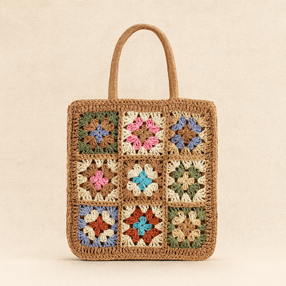 “Front close-up of brown crochet-embroidered straw bag with nine colorful flower squares, by Solmerea.”