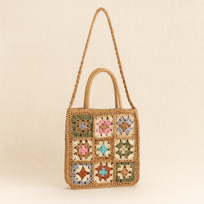 “Brown straw shoulder bag with multicolor crochet flower embroidery in a grid pattern, by Solmerea.”