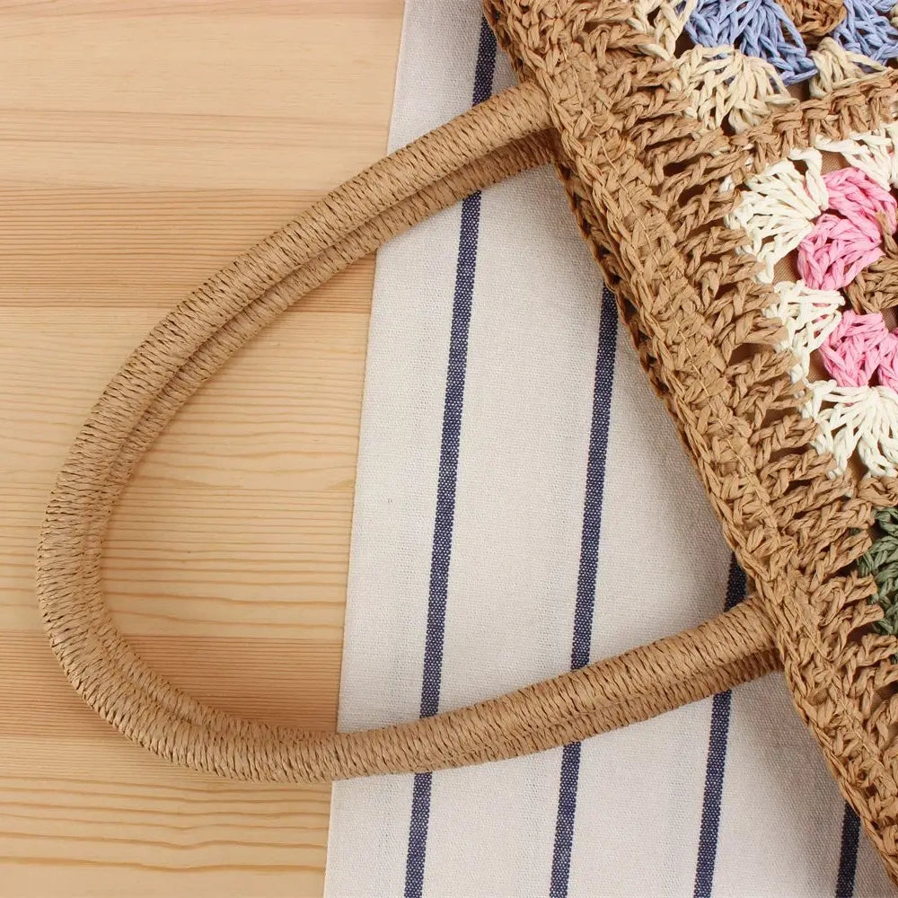 “Close-up of woven straw handle of embroidered shoulder bag showing hand-braided craftsmanship, by Solmerea.”