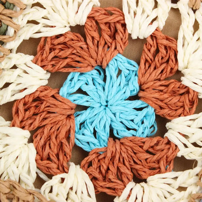 “Close-up of single crochet flower motif in blue, brown, and cream tones on embroidered straw bag, by Solmerea.”