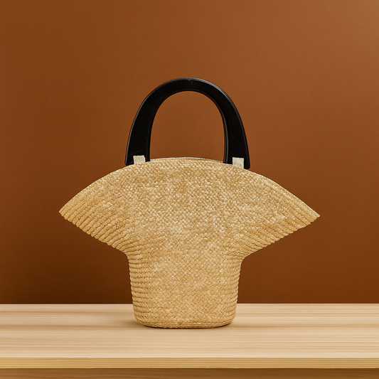 “Handwoven straw clutch with elegant curved silhouette and black wooden handles, natural beige tone, by Solmerea.”
