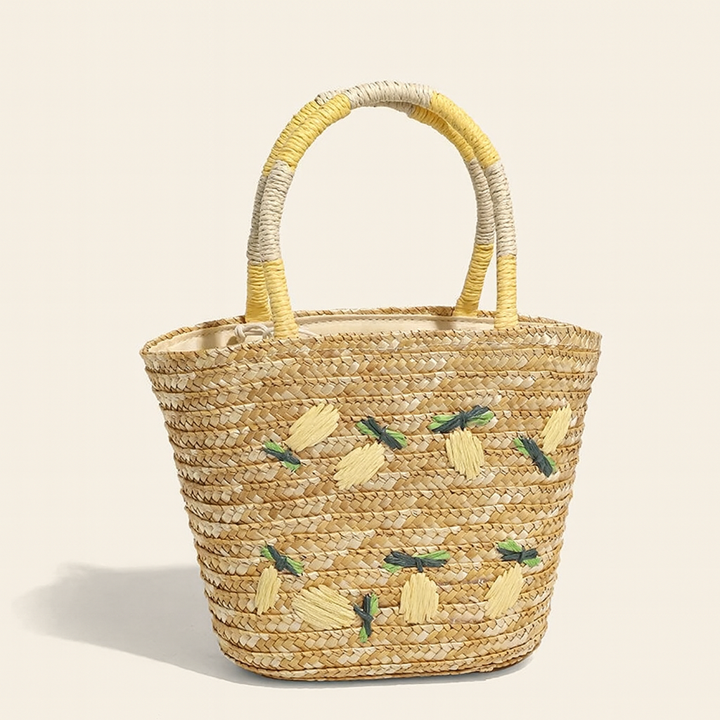 “Front view of lemon-embroidered straw beach tote with yellow and green raffia details, by Solmerea.”