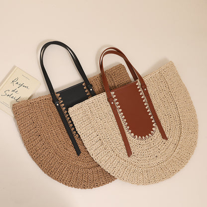 “Flatlay of two semicircular straw clutch bags in beige and brown with leather accents, by Solmerea.”