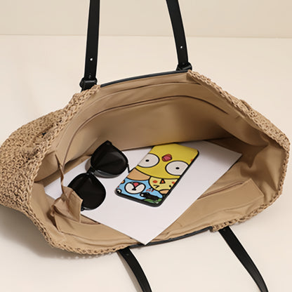 “Open straw clutch with beige lining showing phone and sunglasses inside, spacious interior, by Solmerea.”