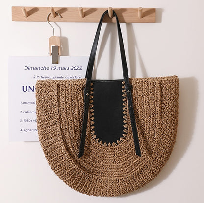 “Brown handwoven straw clutch with black leather accent hanging on minimalist wooden rack, by Solmerea.”