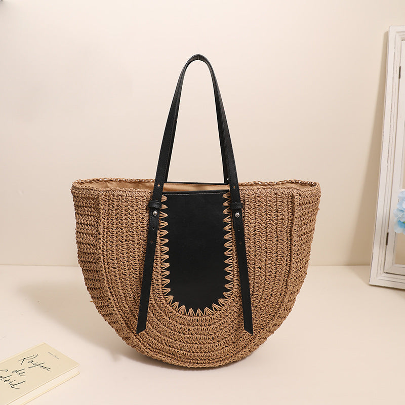 “Dark brown handwoven straw clutch with black leather accent and double handles, by Solmerea.”