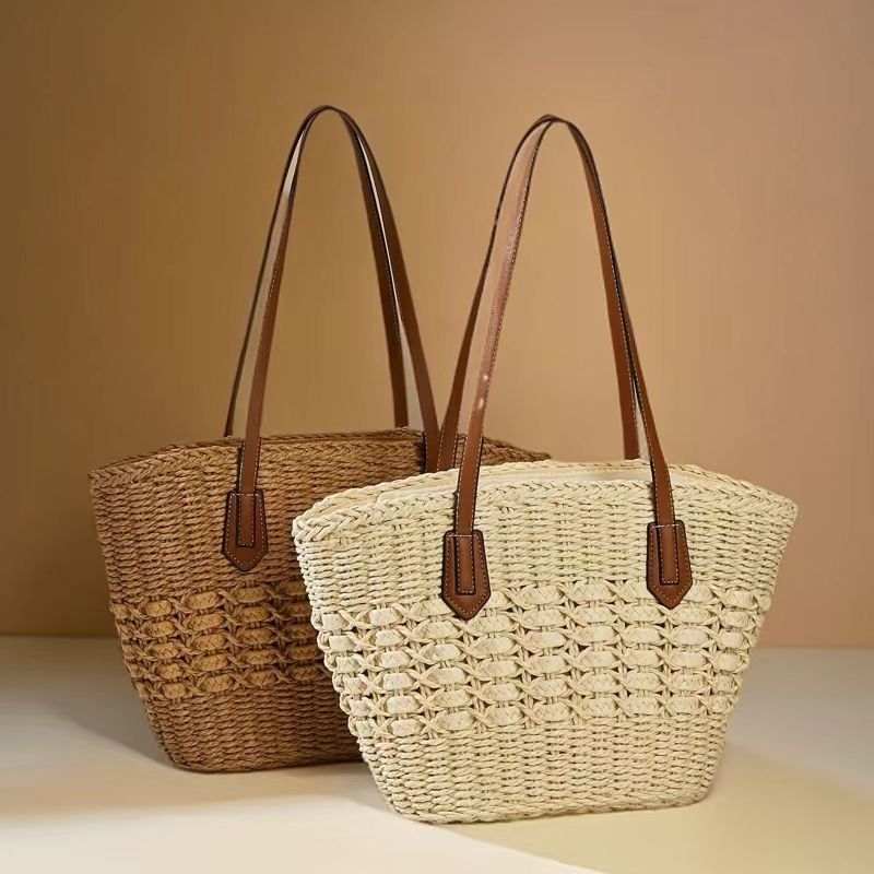 Set of two woven straw shoulder totes in beige and brown with leather straps, by Solmerea.
