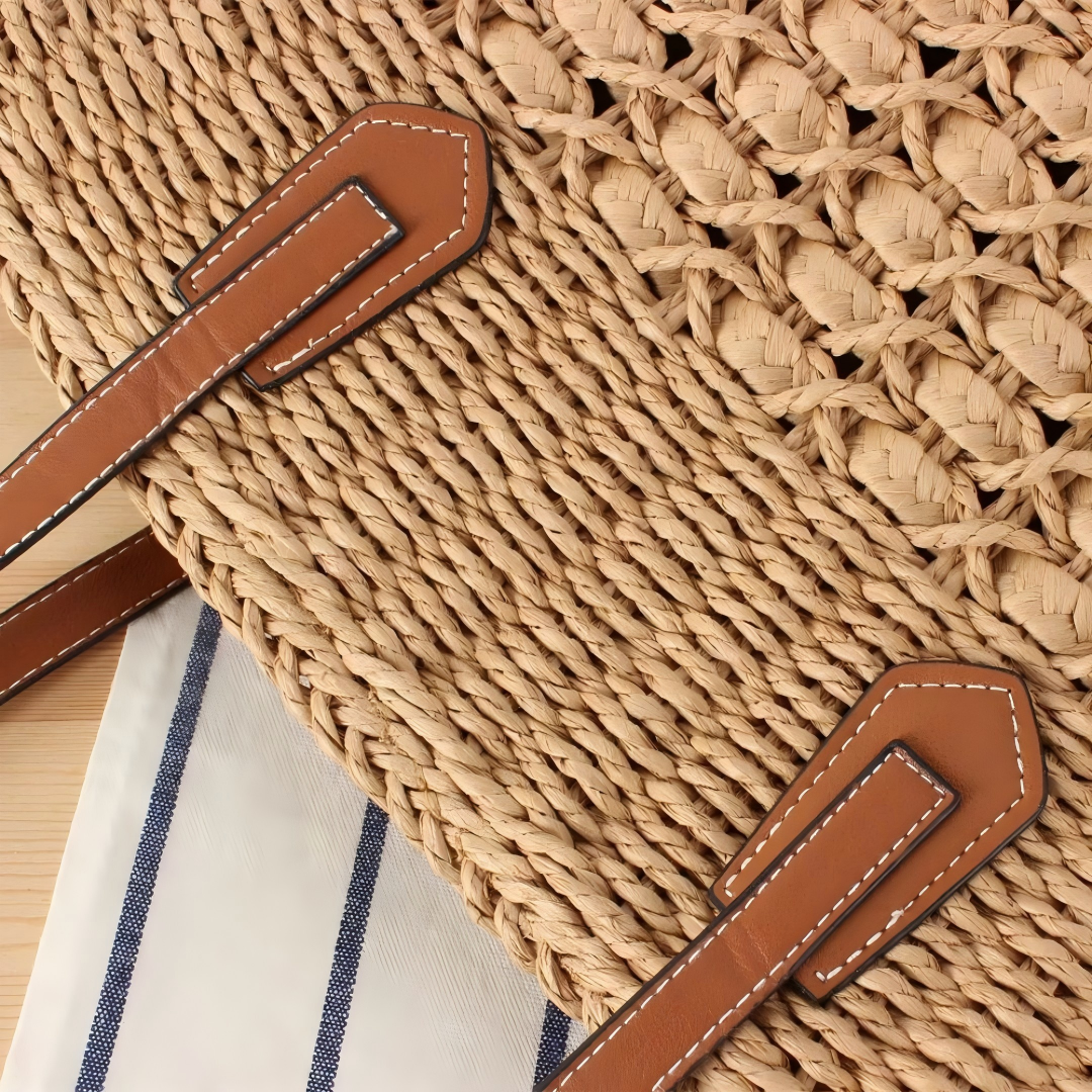 Close-up of leather strap attachment and textured straw weave band detail, by Solmerea.