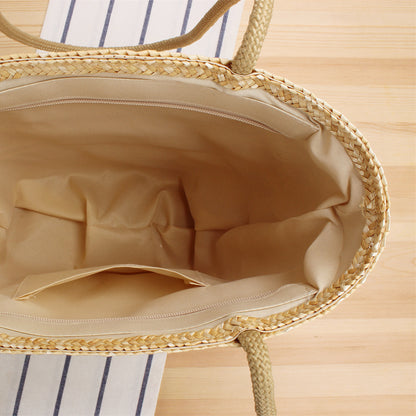Interior view of straw beach tote bag with spacious beige fabric lining and small inner pocket.