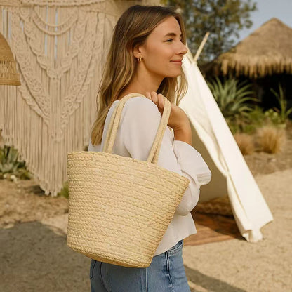 Woman in casual summer outfit carrying a straw beach tote bag outdoors near a bohemian-style tent.