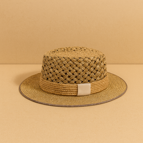 Handwoven straw sun hat with a flat top and cream accent band, displayed on beige background for a minimalist look.