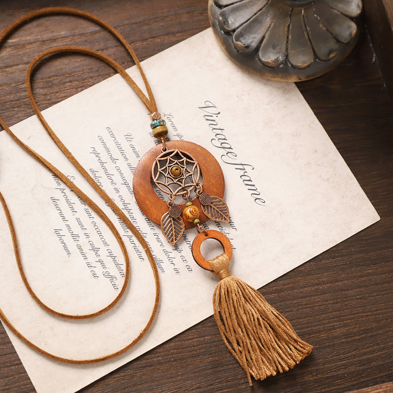 Dreamcatcher wooden necklace with dual rings and long beige tassel in earthy boho style.