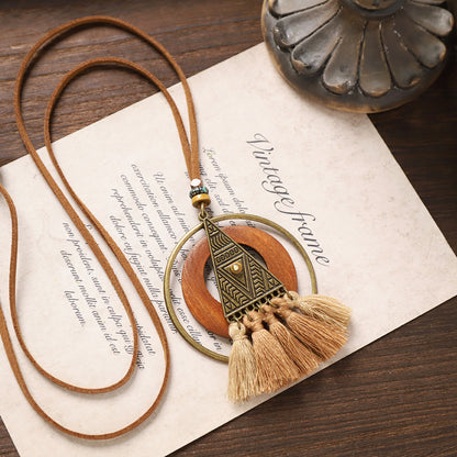 Triangle pendant wooden necklace with geometric brass design and layered tassels.