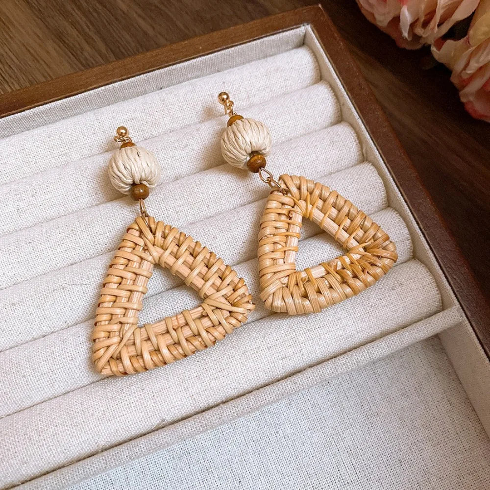 Triangular rattan weave earrings with natural beads displayed in jewelry box.