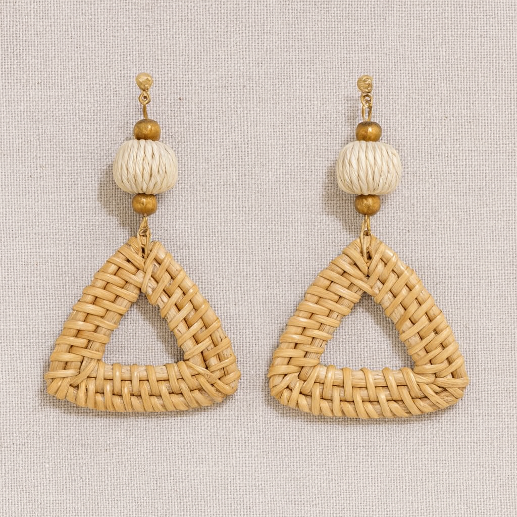 Pair of triangular rattan weave earrings with natural beads on neutral linen background.